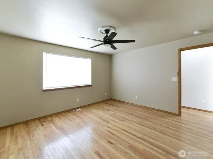 Primary bedroom, faces side of house, with large window that lets in a lot of natural light.