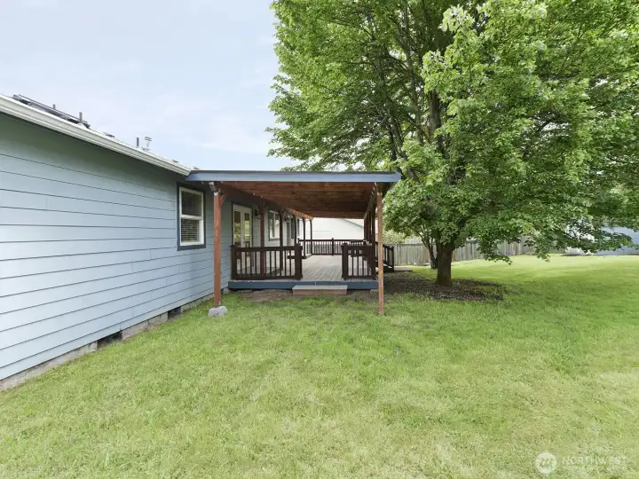 View of covered deck from the side of the yard.