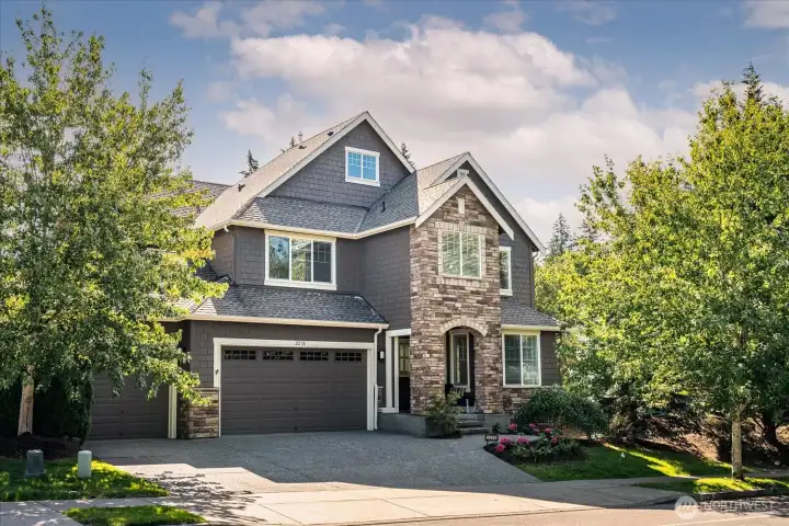 Striking Craftsman architecture and timeless curb appeal welcome you to this impeccably maintained residence, beautifully framed by mature landscaping, rich stone accents, and a grand entry that sets the tone for the exceptional living spaces within.