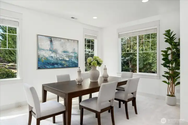 Host unforgettable dinners in this elegant formal dining room, where expansive windows, abundant natural light, fresh interior paint, and plush new carpeting create a warm and sophisticated setting.