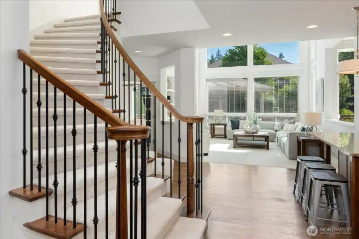 Graceful staircase welcomes you as the home unfolds into an open, light-filled main level, drawing your eye to the majestic family room framed by soaring ceilings and expansive windows.