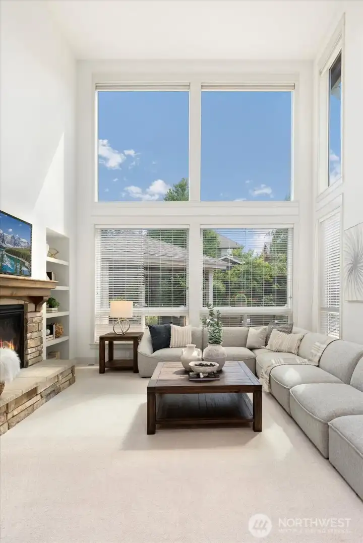 The heart of the home, this majestic family room showcases soaring ceilings, breathtaking two-story windows, and an abundance of natural light, all anchored by a stunning stone fireplace that creates an unforgettable gathering space.