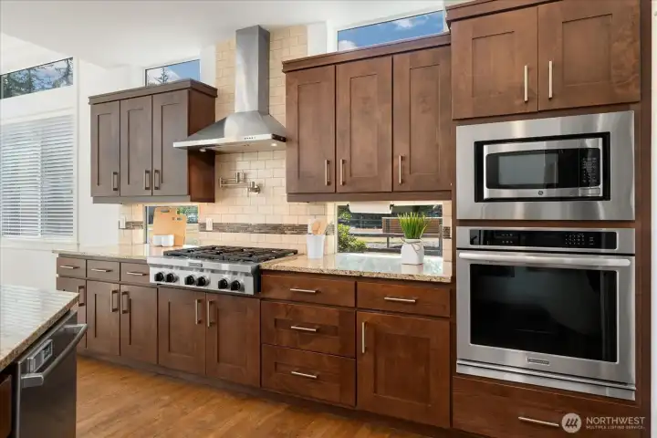 The chef's kitchen features premium stainless-steel oven, a built-in microwave, custom cabinetry, and warm hardwood floors that add timeless elegance.