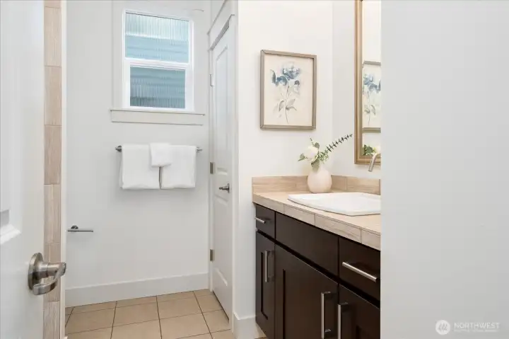 Conveniently located beside the main-level office, this well-appointed ¾ bath features a walk-in shower, modern finishes, and offers the perfect setup for guests or a private fifth-bedroom suite.