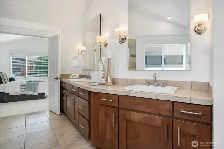 Elegant double vanities, oversized mirrors, and extensive cabinetry create a bright, functional primary ensuite with exceptional storage.