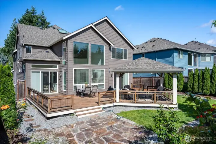 Your private outdoor retreat awaits with an expansive entertainment deck, charming gazebo with power, beautiful stone patio, and professionally landscaped gardens—perfect for relaxing or hosting unforgettable gatherings.