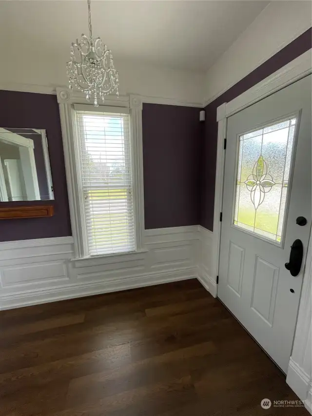 Standing in Archway of Living Rm looking at the Front Entry + Detailed Wainscot & Natural Light.