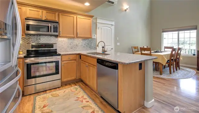 The kitchen features beautiful custom backsplash, stainless appliances and granite countertops.