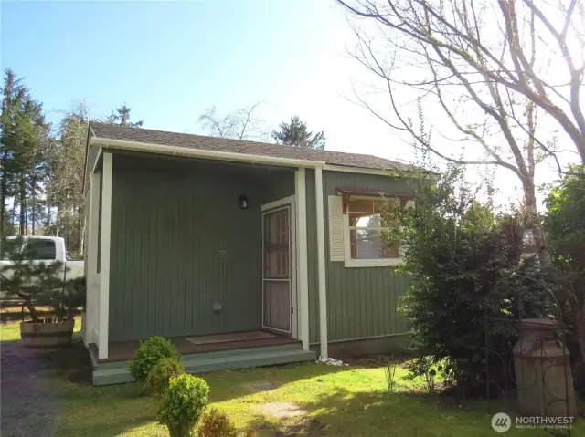 Front porch leads to finished outbuilding which is great space for office, art studio or retreat.