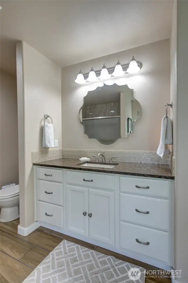 Spacious vanity and tile backsplash compliment the primary bath.
