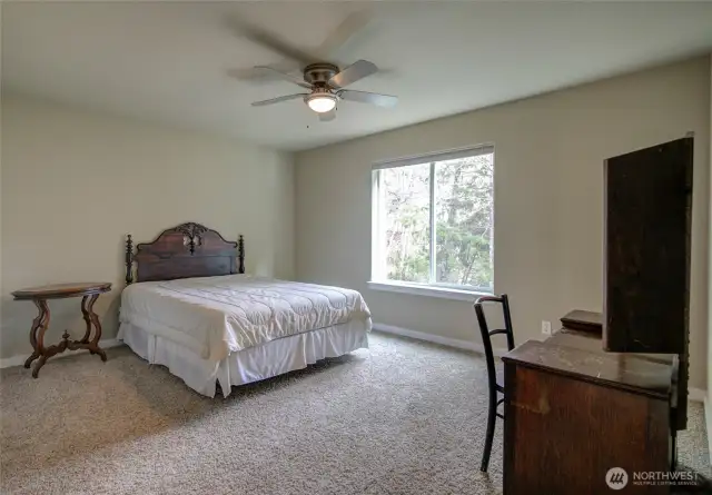 Lovely, spacious room has a ceiling fan and a comfortable, inviting space.