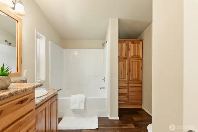 Built in linen in the corner of the bathroom.