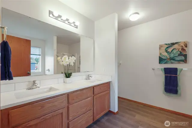 Primary bathroom with double vanities, new quartz countertops, laminate flooring, and new sinks. Everything you need is right here.