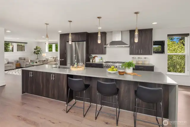 An oversized waterfall kitchen island welcomes you to this entertainers dream of a kitchen.