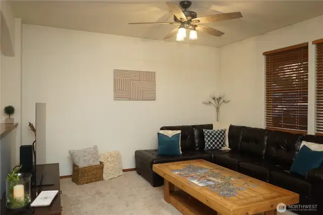 The living room has brand new carpet and fan light.
