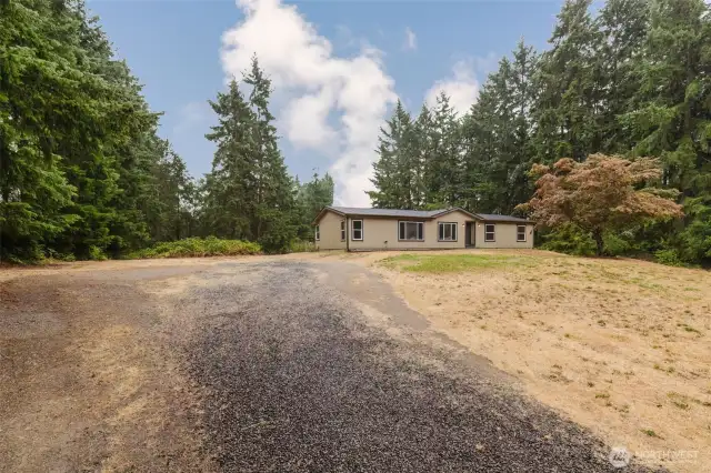 Long driveway leading to home with expansive lot.
