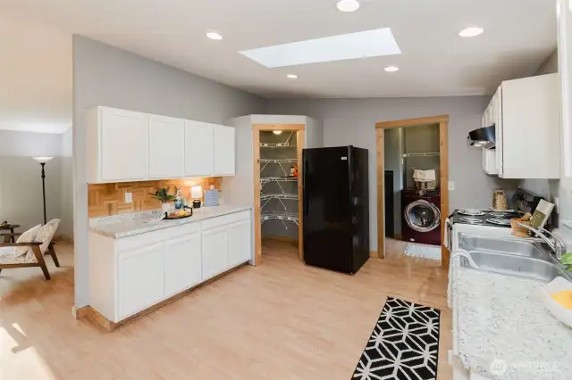 Kitchen with skylight, ample cabinetry, and counter space.