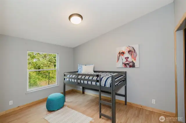Bedroom with natural light and laminate floors.