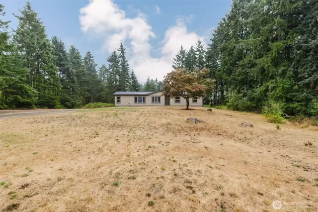 Open backyard with treed backdrop for privacy.