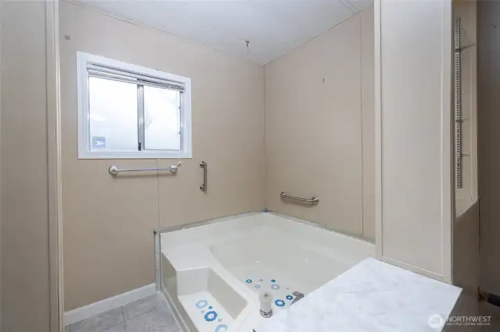 Not visible to the left in this photo, there is a step-in shower  in addition to the deep soaking tub.