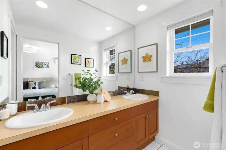Primary ensuite bath featuring a spacious double-sink vanity with generous counter and cabinet space, plus a separate door to the shower and toilet for added privacy.