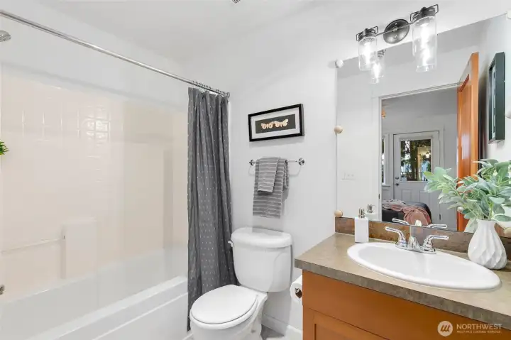 Lower-level ensuite bath with tub and shower, offering privacy and convenience for guests or extended stays.