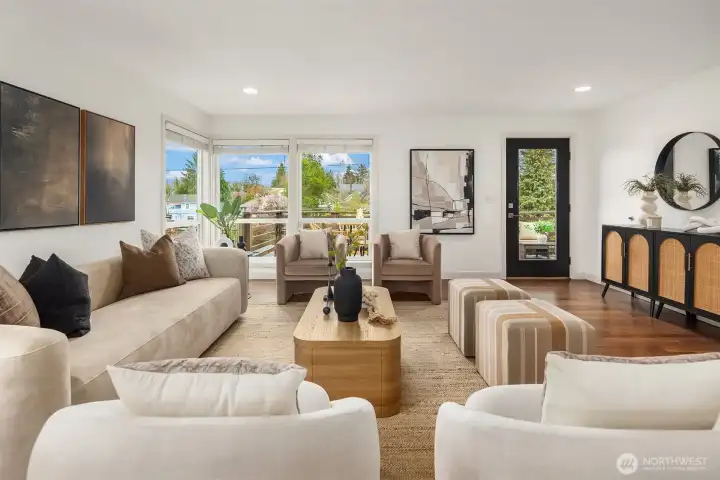 Large living room windows welcome in beautiful natural light, while sunrise skies and twinkling evening lights create a setting that feels both uplifting and serene.