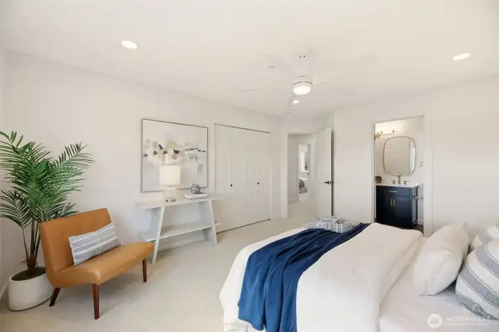 This primary suite features an oversized closet with lighting and organizers, plus a private en-suite bath.