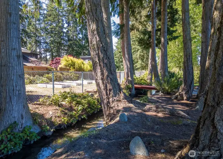 Two darling wooden bridges cross over the irrigation creek to the fenced garden and pet areas