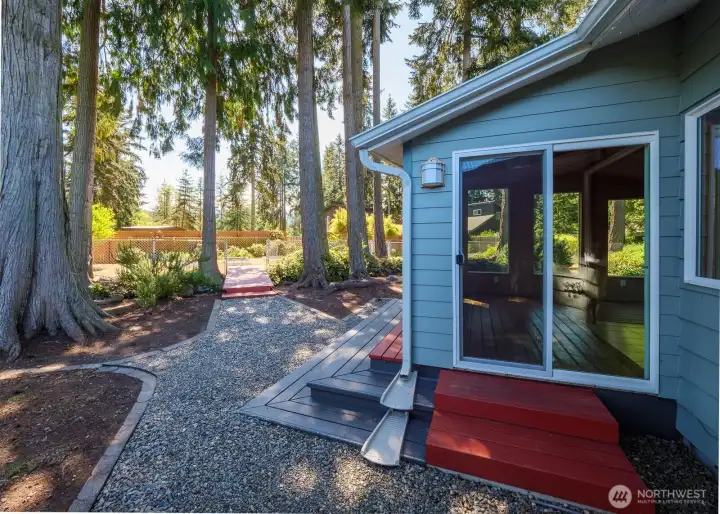 The slider off of the sunroom and the door from the garage both open onto the graveled path to the first bridge across the creek.