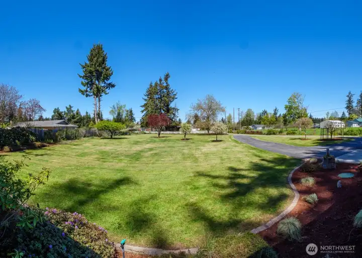 The beautifully manicured front yard features apple, pear, peach, plum, walnut, and flowering plum trees.