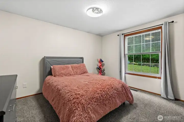 Room for everyone. This well-proportioned bedroom features ample closet space and a practical footprint, providing a cozy and private retreat within this single-level home.