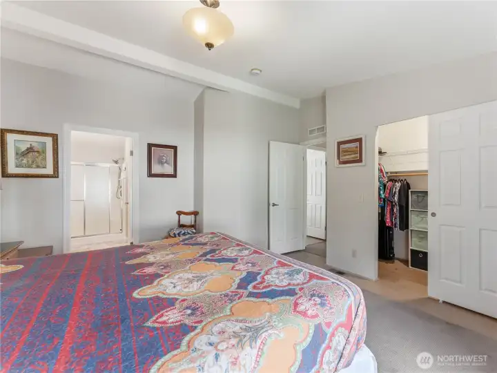 Primary bedroom showcasing vaulted ceilings and a bright, airy atmosphere.