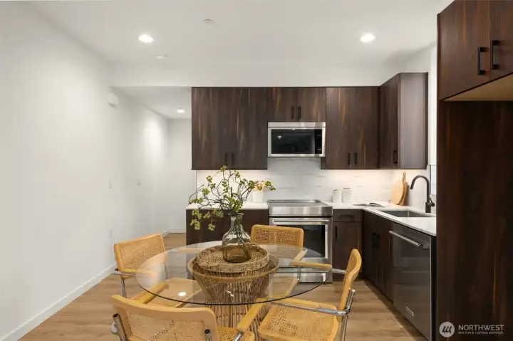 An intimate dining space sits adjacent to the kitchen, framed by large windows that invite natural light into every meal. An intimate dining space sits adjacent to the kitchen, framed by large windows that invite natural light into every meal.