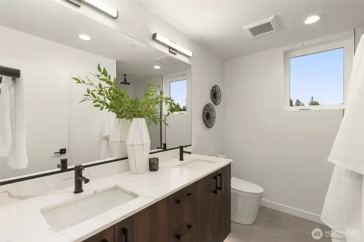 The spa-inspired primary bathroom features a crisp modern vanity, contemporary fixtures, and pristine tile work. The spa-inspired primary bathroom features a crisp modern vanity, contemporary fixtures, and pristine tile work.