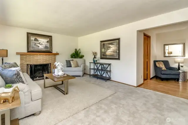 Living room off of entry, library & hallway features a wood burning fireplace.