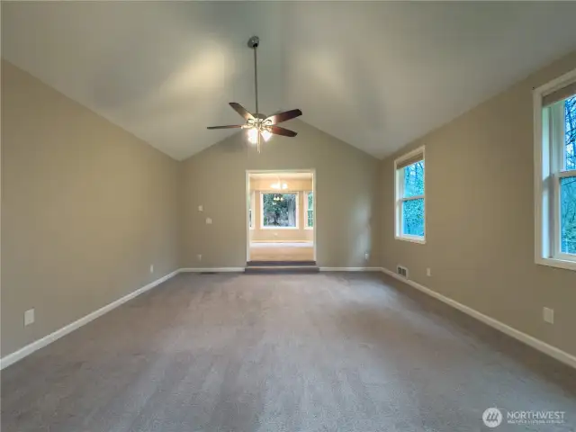 Living room looking into the dining room from the sun room. Vaulted ceilings.