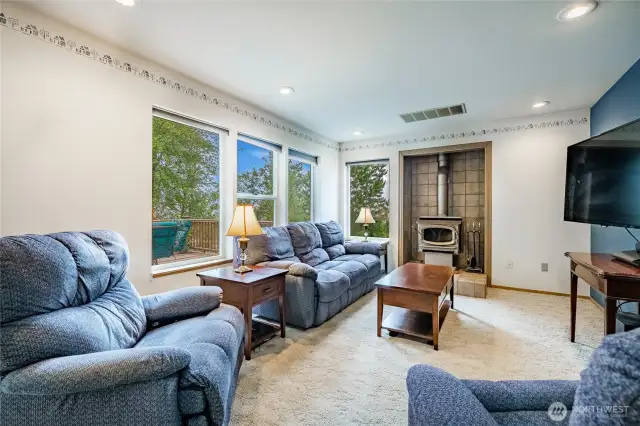 Family Room with wood stove and views of Canadian mountains and peek-a-boo view of Bellingham Bay