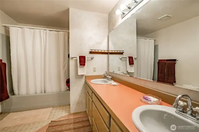 Primary bathroom with double sinks and tub/shower