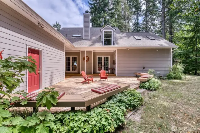 Large entermain deck with access from hall or living room double doors.  Additional seating benches on edge of the deck.  Back door to garage to the left.