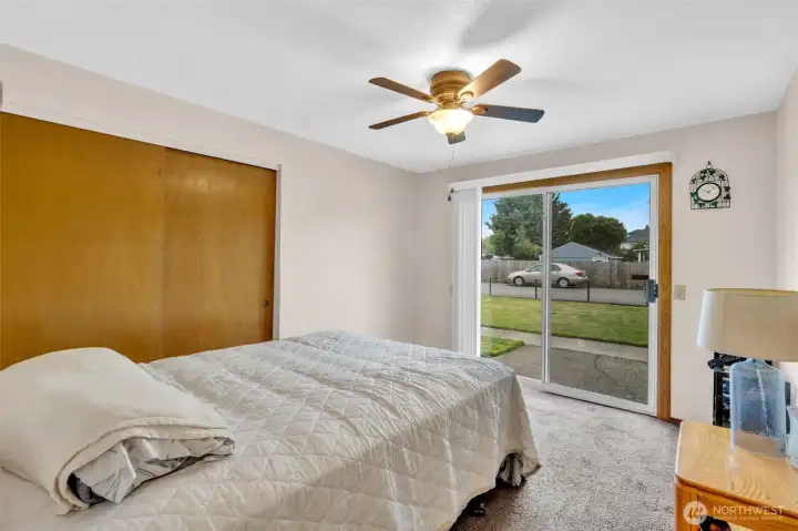 Primary bedroom with slider to side yard patio.