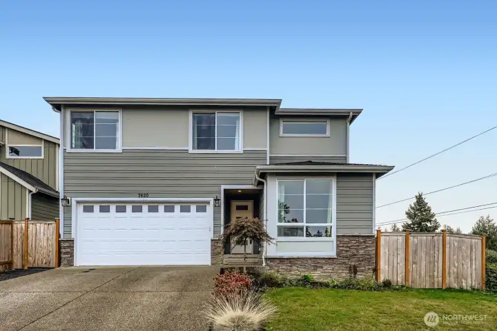 Front exterior with landscaped yard and covered entry.