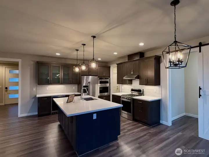 Modern kitchen with stainless steel appliances, ample counter space, and breakfast bar.