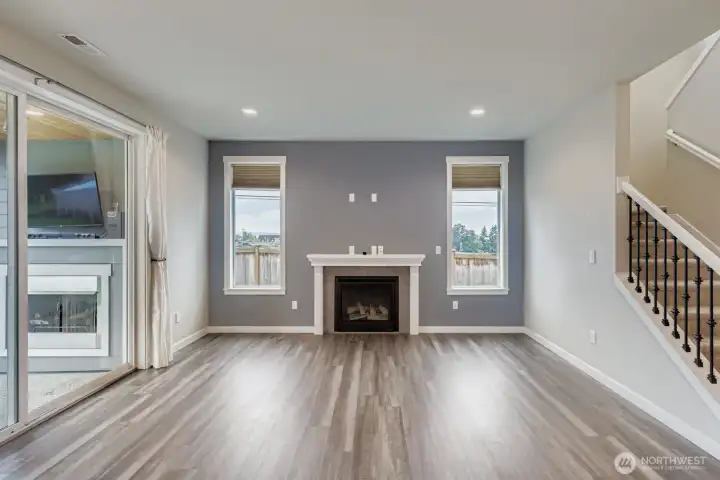 Great room fireplace with view of covered patio fireplace through sliding glass door.
