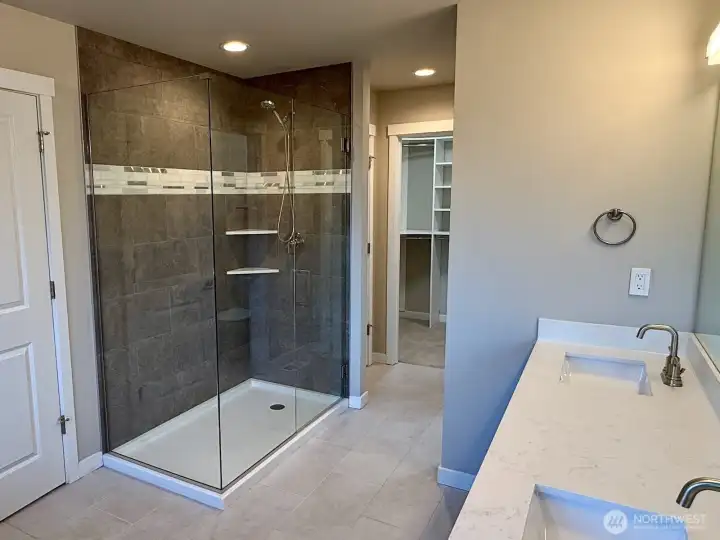 Master bathroom featuring dual sinks, shower, and soaking tub.