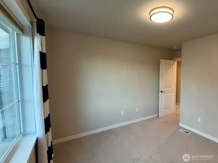 This secondary bedroom between the other two looks out over the street.