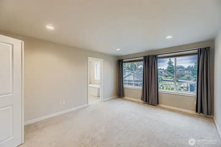 Primary bedroom with south-facing windows and abundant light.