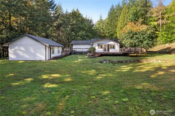 View of the large deck and 1st garage w/ workshop.
