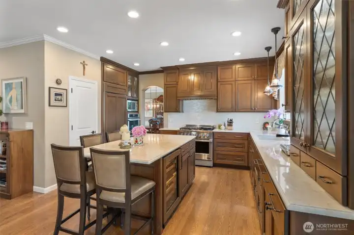 The stunning kitchen boasts solid Cherry cabinetry with leaded-glass accents, under-cabinet lighting, Quartzite countertops, glass tile backsplash, Sub-Zero fridge and wine cooler, 6-burner DCS range with commercial-grade hood, 2nd oven by Thermador, two roll-out dishwashers, Insta-hot water, roll-out drawers, and walk-in pantry.