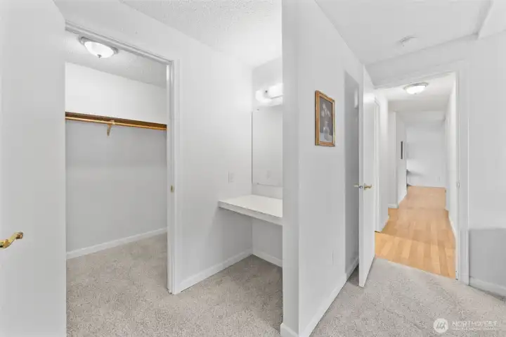 Primary bedroom has a lighted, mirrored vanity and a walk-in closet